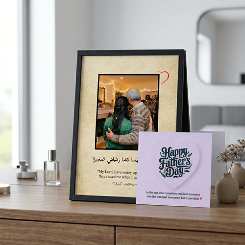 Framed photo of father-daughter with a 'Happy Father's Day' card on a wooden surface.
