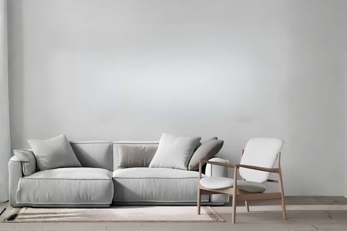 Gray sectional sofa with a chair against a plain wall